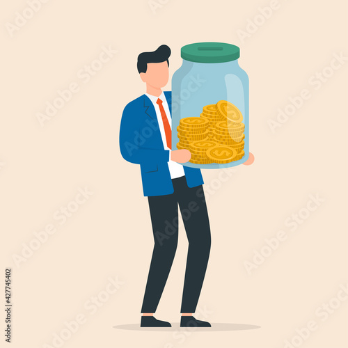 Businessman holding glass jar with full of coins. Saving income in glass bottle for retirement or deposit.
