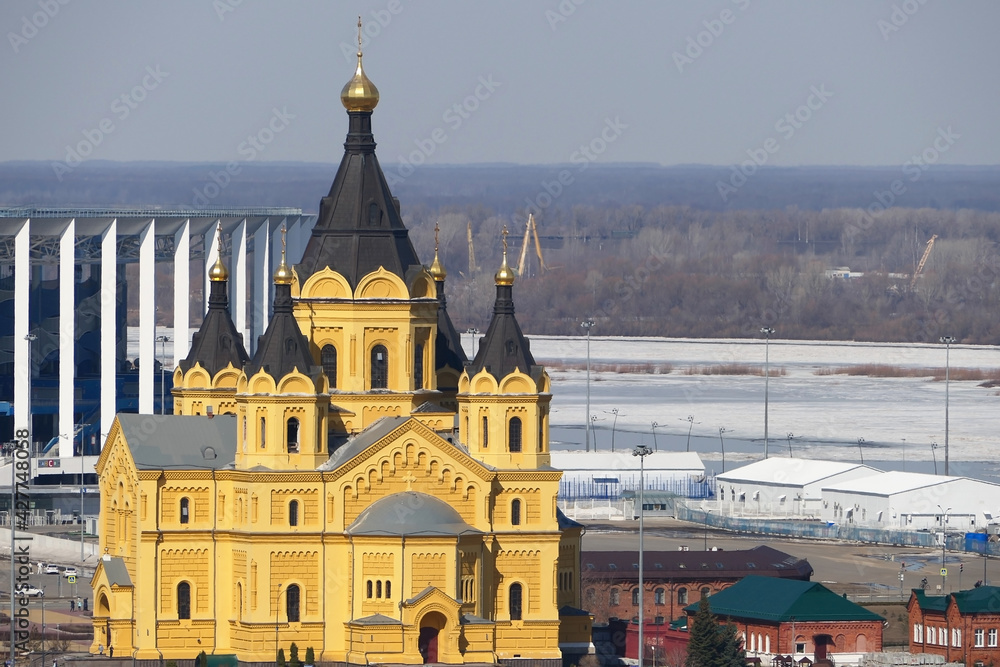 Obraz premium Beautiful Orthodox church made of yellow brick on the river bank. Alexander Nevsky Cathedral on in Nizhny Novgorod, Russia. High