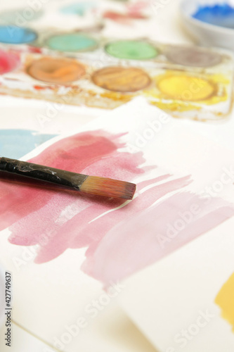Fotografia Watercolor paints palette, brushes and papers on table
