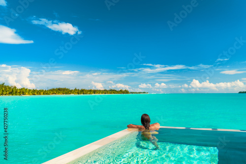 Luxury swimming pool spa resort travel honeymoon destination woman relaxing in infinity pool at hotel nature background summer holiday.