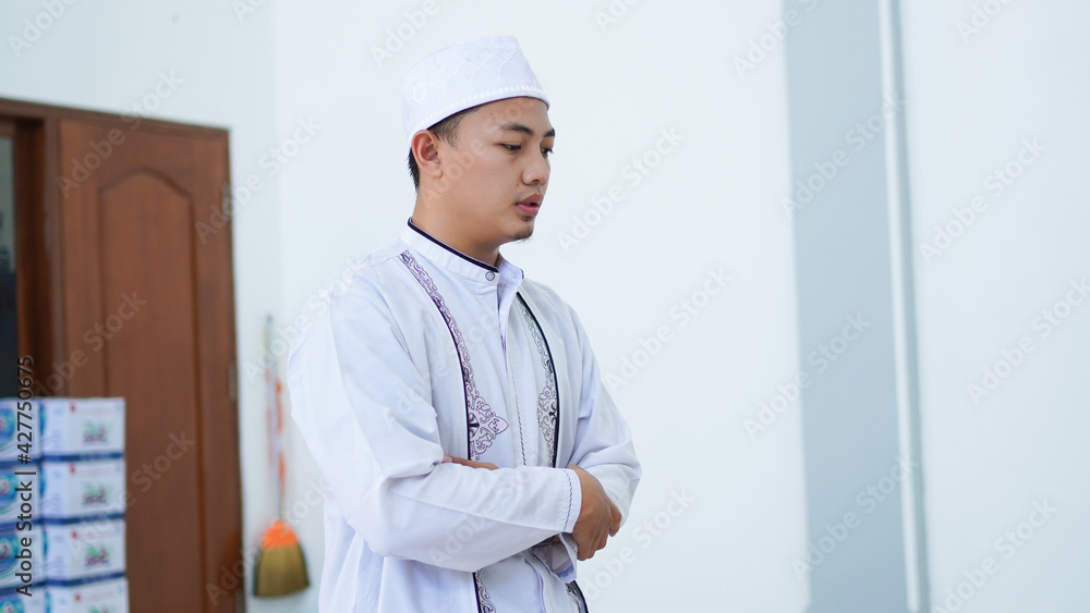 A portrait of an asian muslim man pray at mosque, the pray name is sholat, takbiratul ihram