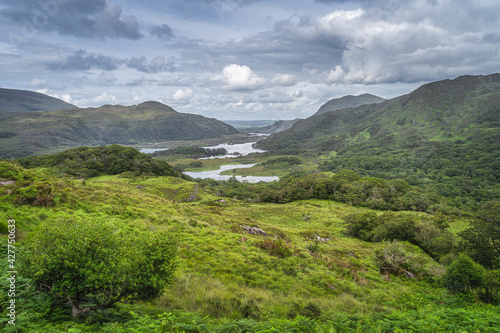 Patches of sunlight illuminating trees, meadows and mountains on Irish iconic viewpoint, Ladies View, Killarney, Rink of Kerry, Ireland