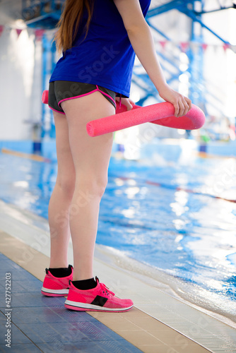 A trainer near the sports swimming pool trains aqua aerobics.