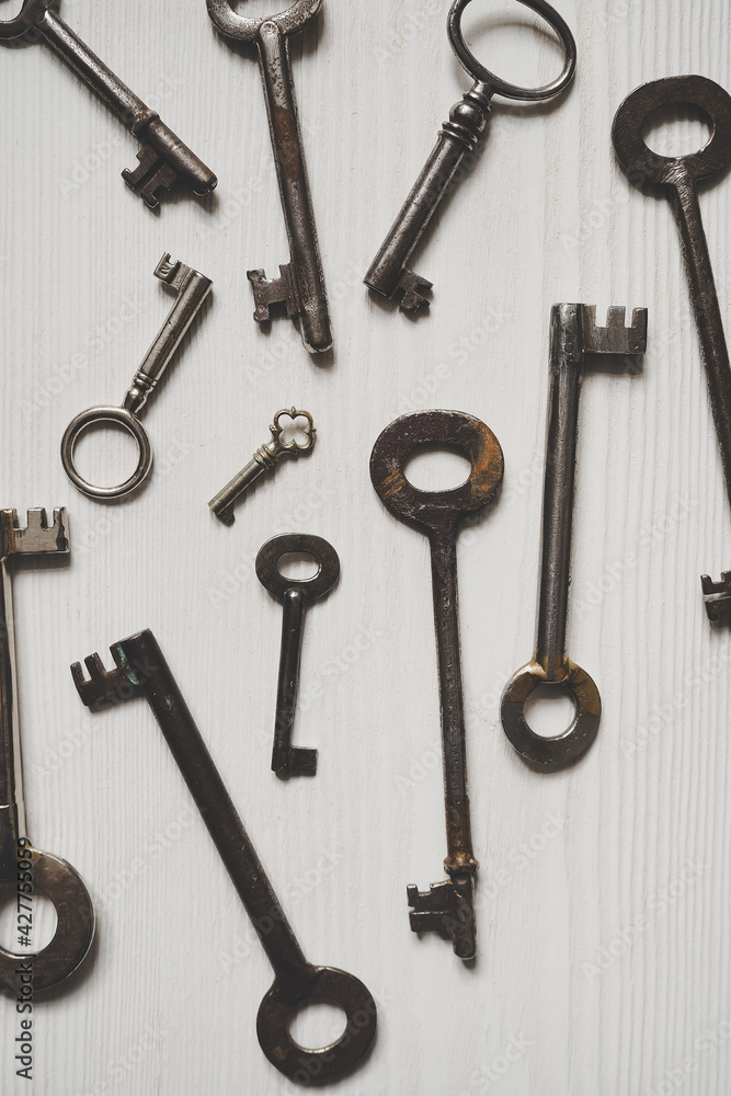 Different old fashioned keys on a white table Different old fashioned keys on a white table