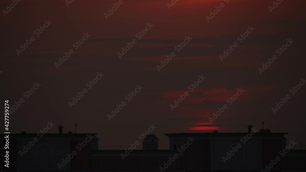 Red sun goes down behind the building silhouette Red sun goes down behind the building silhouette