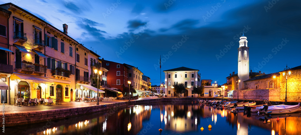 Boats in old town port of Lazise at twilight. The town is a popular holiday destination in Garda Lake district.