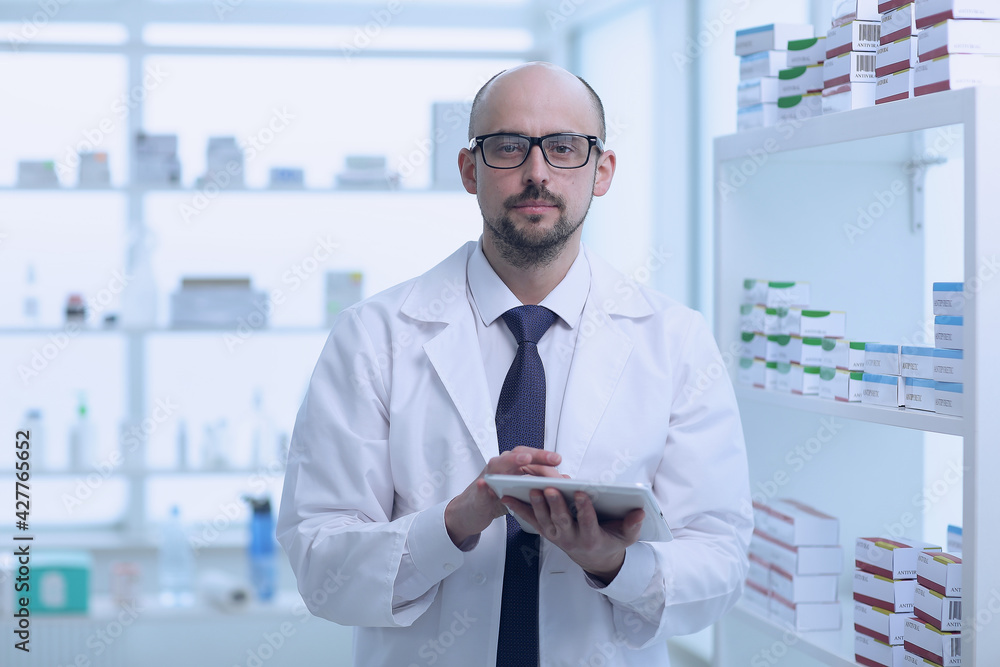 Pharmacist is working. Man wearing special medical uniform located in pharmacy. Pharmacist is working. Man wearing special medical uniform located in pharmacy.