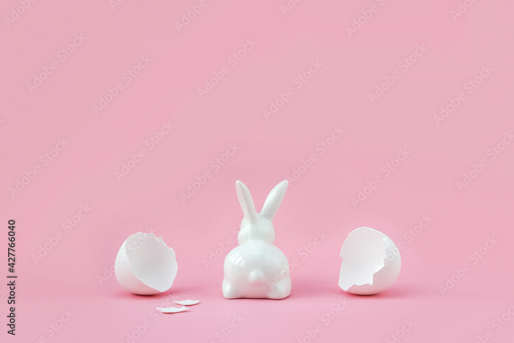 Porcelain figurine of bunny and broken eggshell. Minimal creative Easter concept. Place for your text. Selective focus. Porcelain figurine of bunny and broken eggshell. Minimal creative Easter concept. Place for your text. Selective focus.