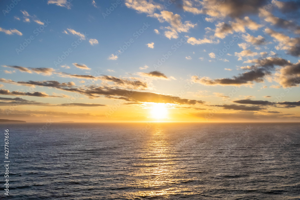 A dramatic sunset over the ocean with colorful skies and color being reflected in the waves below. A dramatic sunset over the ocean with colorful skies and color being reflected in the waves below.