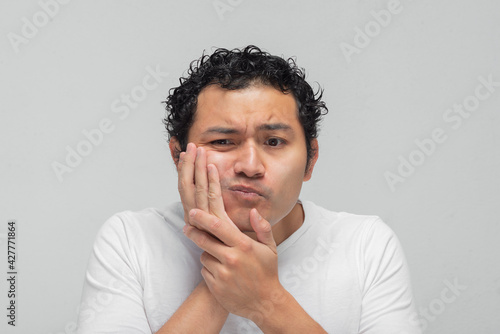 Konstfotografi joven hispano mexicano con dolor de muela