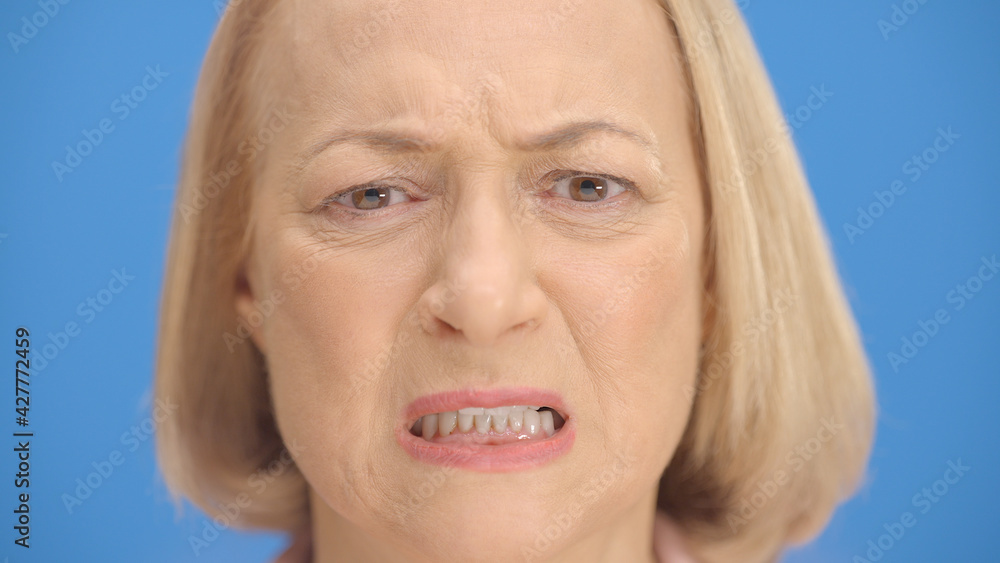 Old woman face gets angry in front of the Blue Background. The old ...