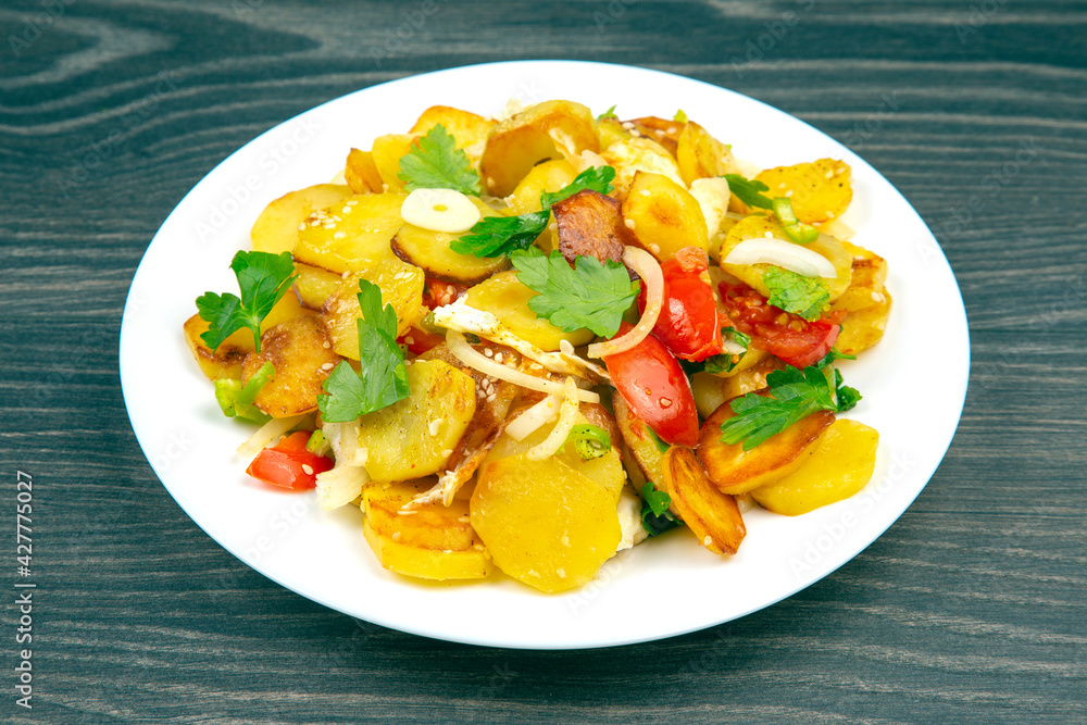 cooked fried potatoes with herbs and vegetables in a white plate on a wooden table cooked fried potatoes with herbs and vegetables in a white plate on a wooden table