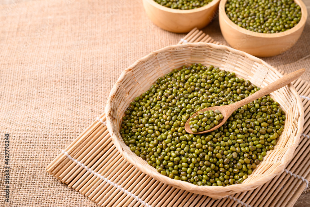 Mung bean seeds in wooden spoon and bamboo basket, Food ingredients in Asian cuisine and produce mung bean sprout Mung bean seeds in wooden spoon and bamboo basket, Food ingredients in Asian cuisine and produce mung bean sprout
