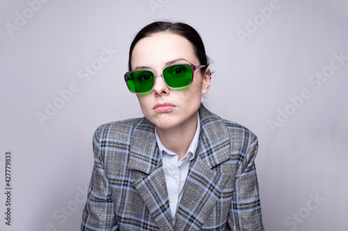 female boss in a cage suit and green glasses