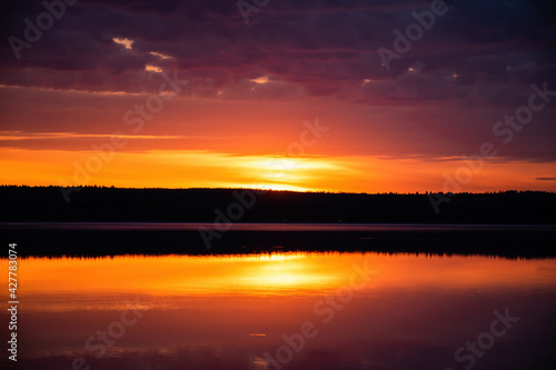 Sunrise with low clouds reflecting in water
