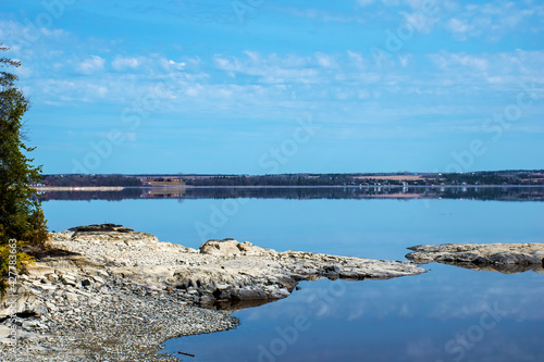 Glass calm lake with rocks and reflections © Robin