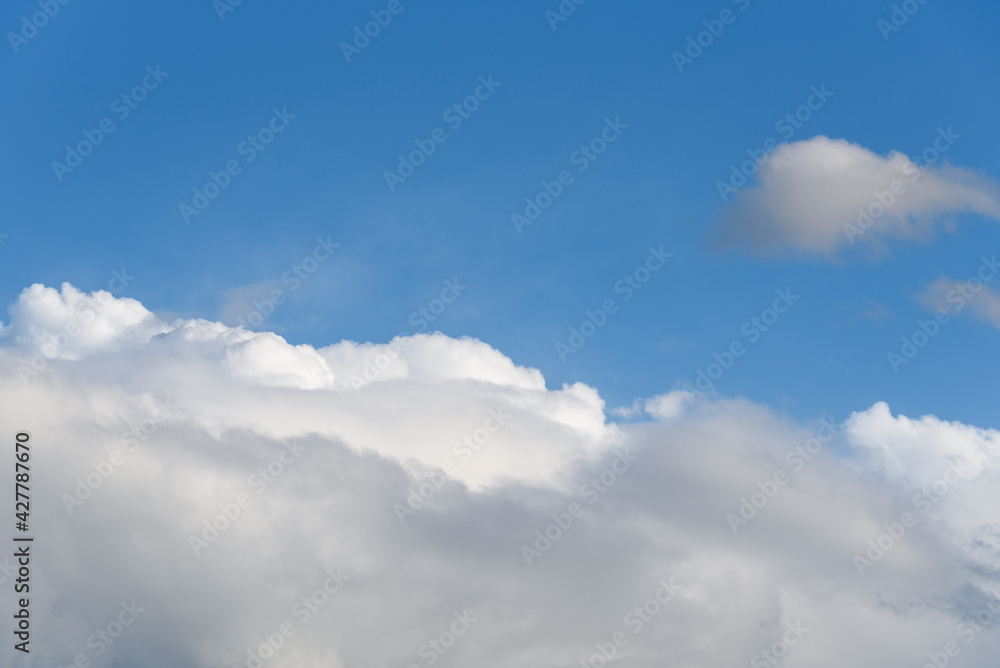 Blue sky with white clouds on a spring day as a nature background
