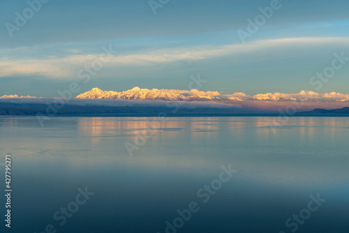 Snowcapped Cordillera Real mountain range reflection near La Paz with sunset reflection in the Titicaca Lake  Sun Island  Isla del Sol   Bolivia.