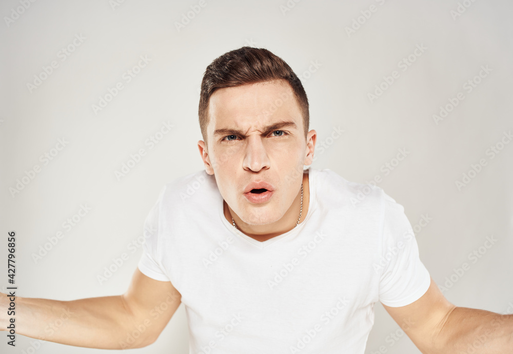 Surprised man spreads his hands to the sides on a light background cropped view Surprised man spreads his hands to the sides on a light background cropped view