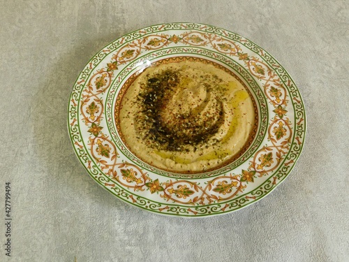 homemade hummus with herbs and olive oil in a traditional oriental dish. vegetarian, healthy food.