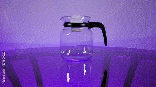 Teabag spins into a Glass-Pot standing on a Glass-Table with purple Light - Slowmotion photo