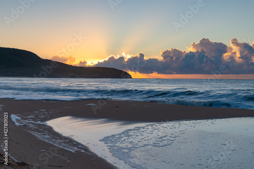 Sunrise at the seaside with low cloud bank