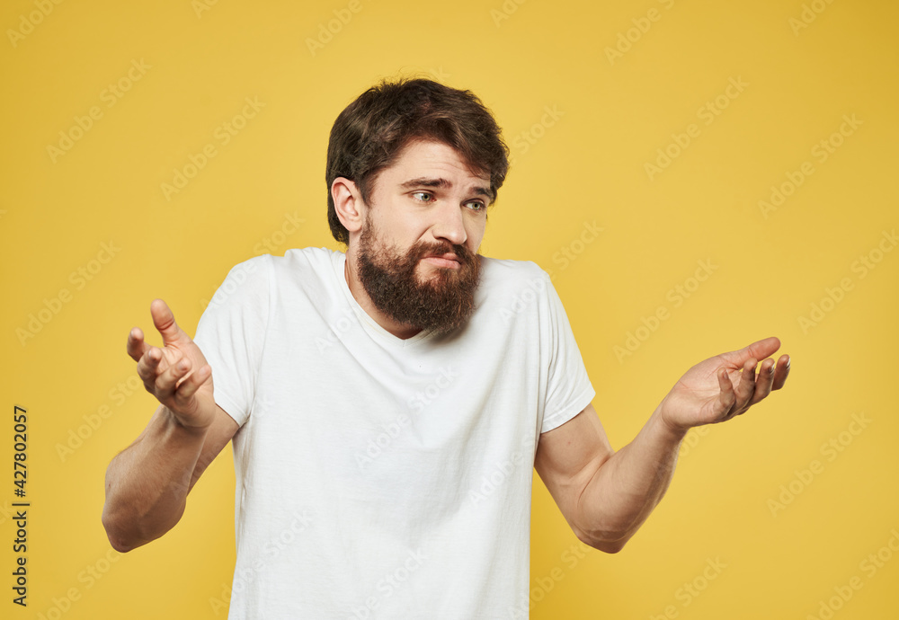 Emotional man on a yellow background in a white t-shirt thick beard brunette model Emotional man on a yellow background in a white t-shirt thick beard brunette model