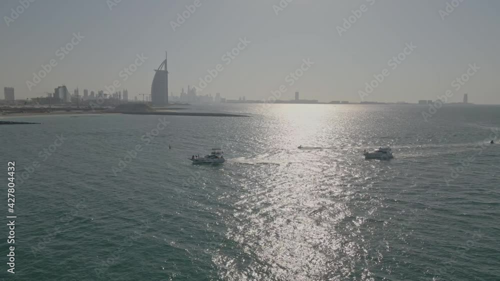 Luxury yachts cruising on Dubai coast United Arab Emirates on sunset aerial view Luxury yachts cruising on Dubai coast United Arab Emirates on sunset aerial view