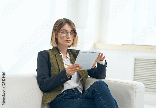 Business woman with a folder of documents and in a classic suit indoors 