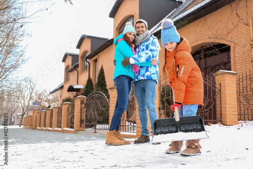 Family removing snow outdoo...