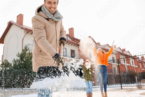 Family removing snow outdoo...
