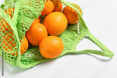 Fresh oranges in eco bag on white background