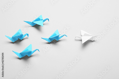 Origami cranes on light background. Concept of uniqueness