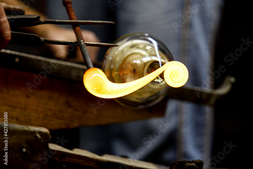 Neman plant, glass blowers, Berezovka. Crystal production, glass museum, vase, Brezhnev Myagkov Glassblower forming the beautiful piece of glass. The glass master burns and blows out the work of art. photo