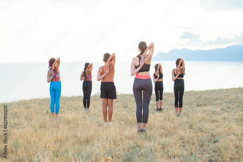 Instructor trains yoga kids in the mountains on the ocean. Instructor trains yoga kids in the mountains on the ocean.