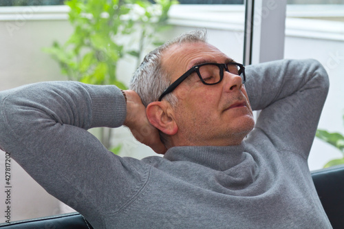 satisfied and relaxed man on the sofa at home photo