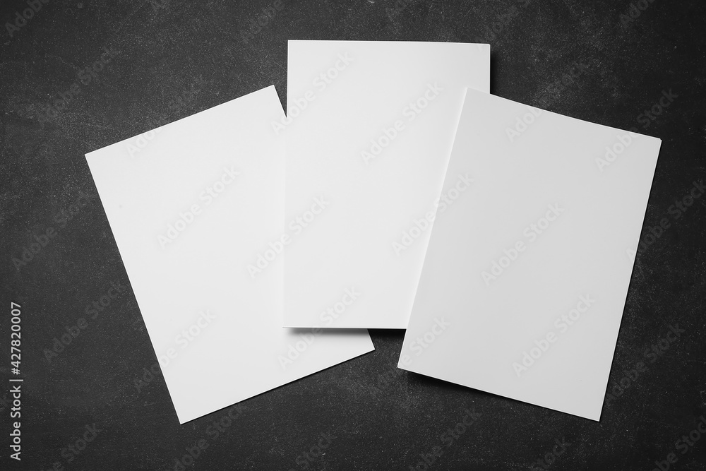 Blank sheets of paper on dark background