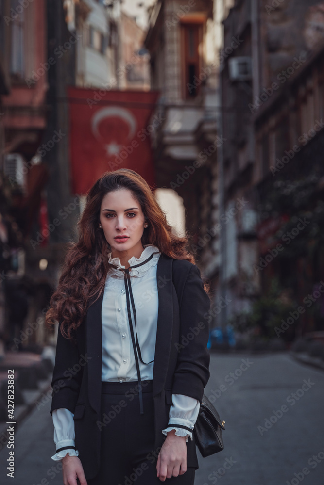 Beautiful stylish young woman walking the atmospheric streets of Istanbul