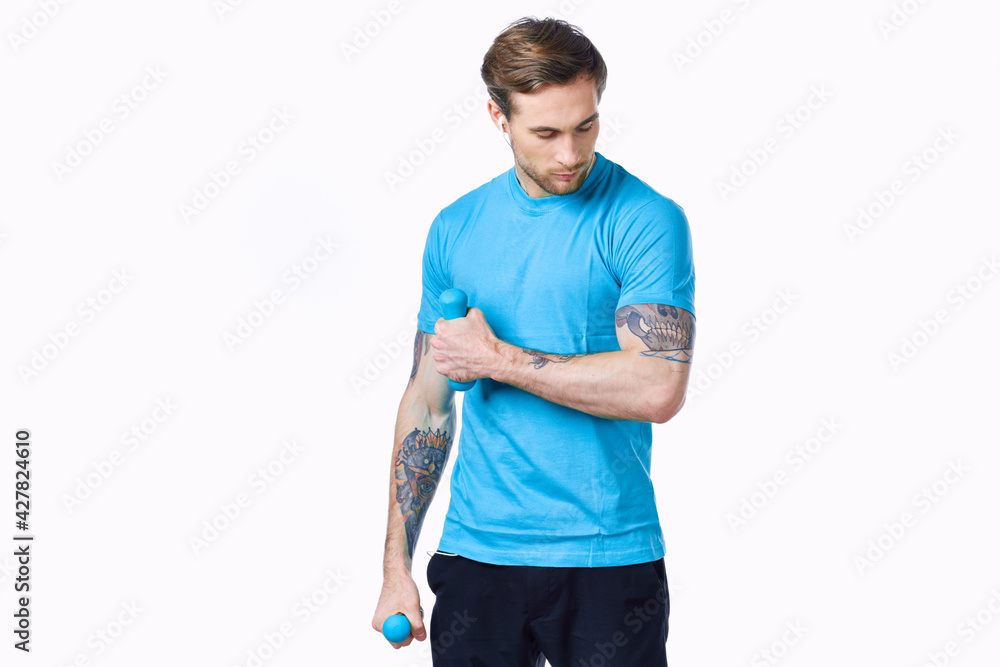 sporty man with a tattoo on his arm in a blue t-shirt and muscles bodybuilding fitness sporty man with a tattoo on his arm in a blue t-shirt and muscles bodybuilding fitness