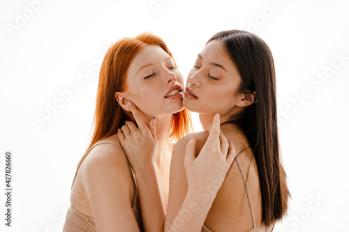 Two young multiethnic women standing posing together