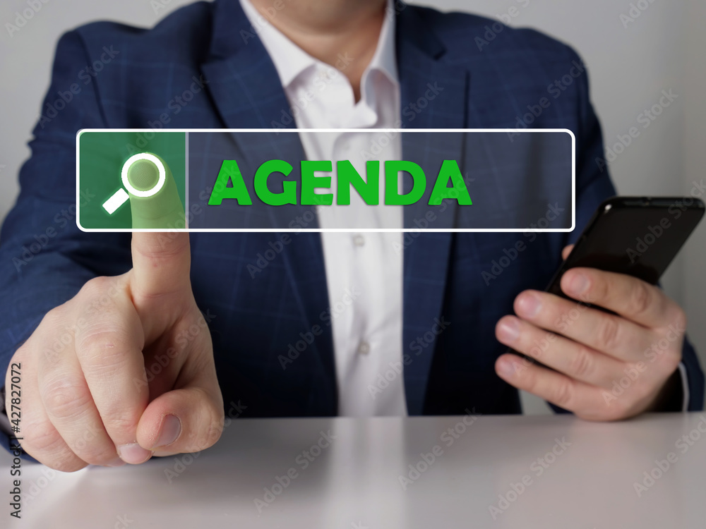 AGENDA text in search bar. Businessman looking for something at cellphone. AGENDA concept. AGENDA text in search bar. Businessman looking for something at cellphone. AGENDA concept.