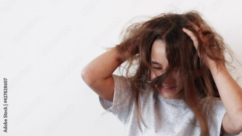 Amused kid. Fun childhood. Positive lifestyle. Excited joyful naughty little girl enjoying tossing hair smiling isolated on light neutral background. Amused kid. Fun childhood. Positive lifestyle. Excited joyful naughty little girl enjoying tossing hair smiling isolated on light neutral background.