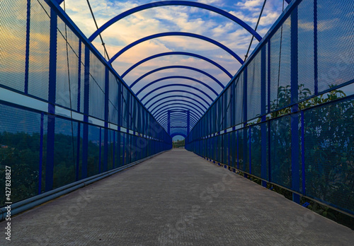 Blue bridge with concrete floor and a sunset in the background, metal structures in Teziutlan Puebla Mexico  #427828827