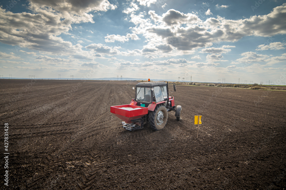 Fototapeta premium Tractor spreading artificial fertilizers