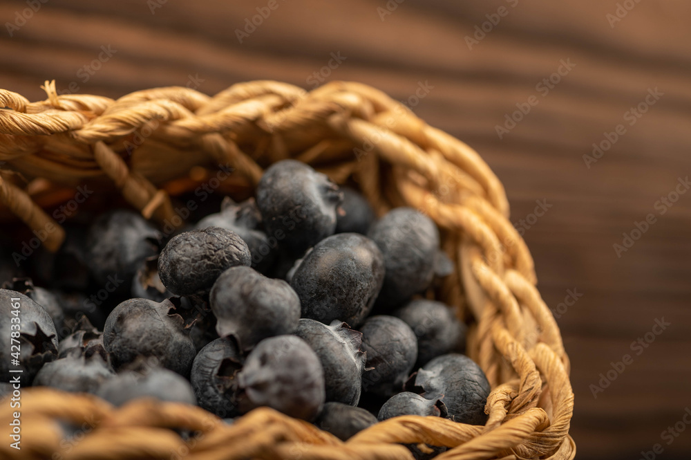 Fresh blueberries in a wicker basket on a wooden table. Harvest, village breakfast. Fresh blueberries in a wicker basket on a wooden table. Harvest, village breakfast.