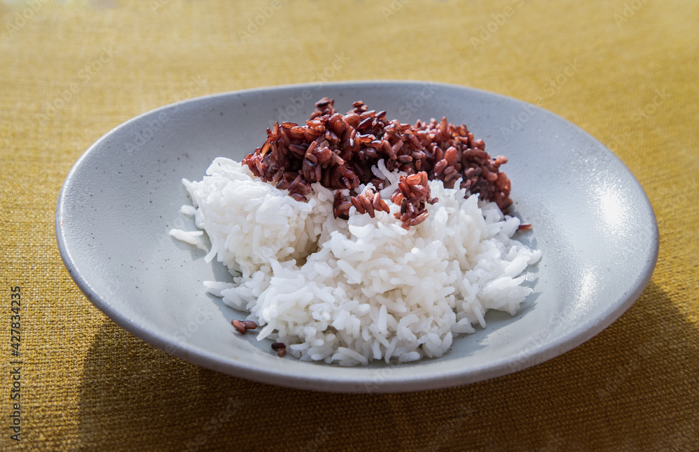 Riceberry and Jasmine rice in white plate. Healthy food and diet concept, Selective focus. Riceberry and Jasmine rice in white plate. Healthy food and diet concept, Selective focus.