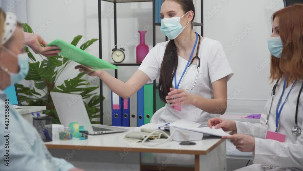 A patient arrived in a wheelchair from the trauma unit to the doctor's room for a routine check-up. A protective mask covering her mouth and nose. A patient arrived in a wheelchair from the trauma unit to the doctor's room for a routine check-up. A protective mask covering her mouth and nose.