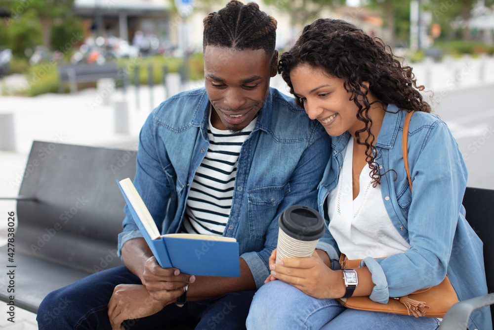 cute young couple with book on romantic date in park cute young couple with book on romantic date in park