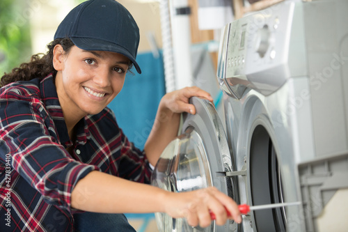young woman repairing a washing machine
