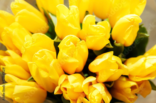 A bouquet of yellow tulips close-up. Beautiful yellow flowers with green leaves. Background with flowers. Flowers for the holiday. Many buds of yellow tulips.